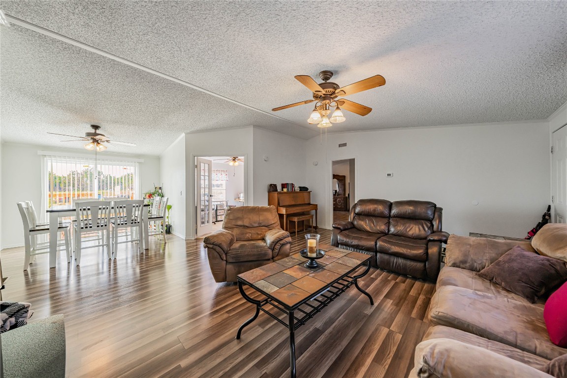 a living room with furniture a ceiling fan and a rug