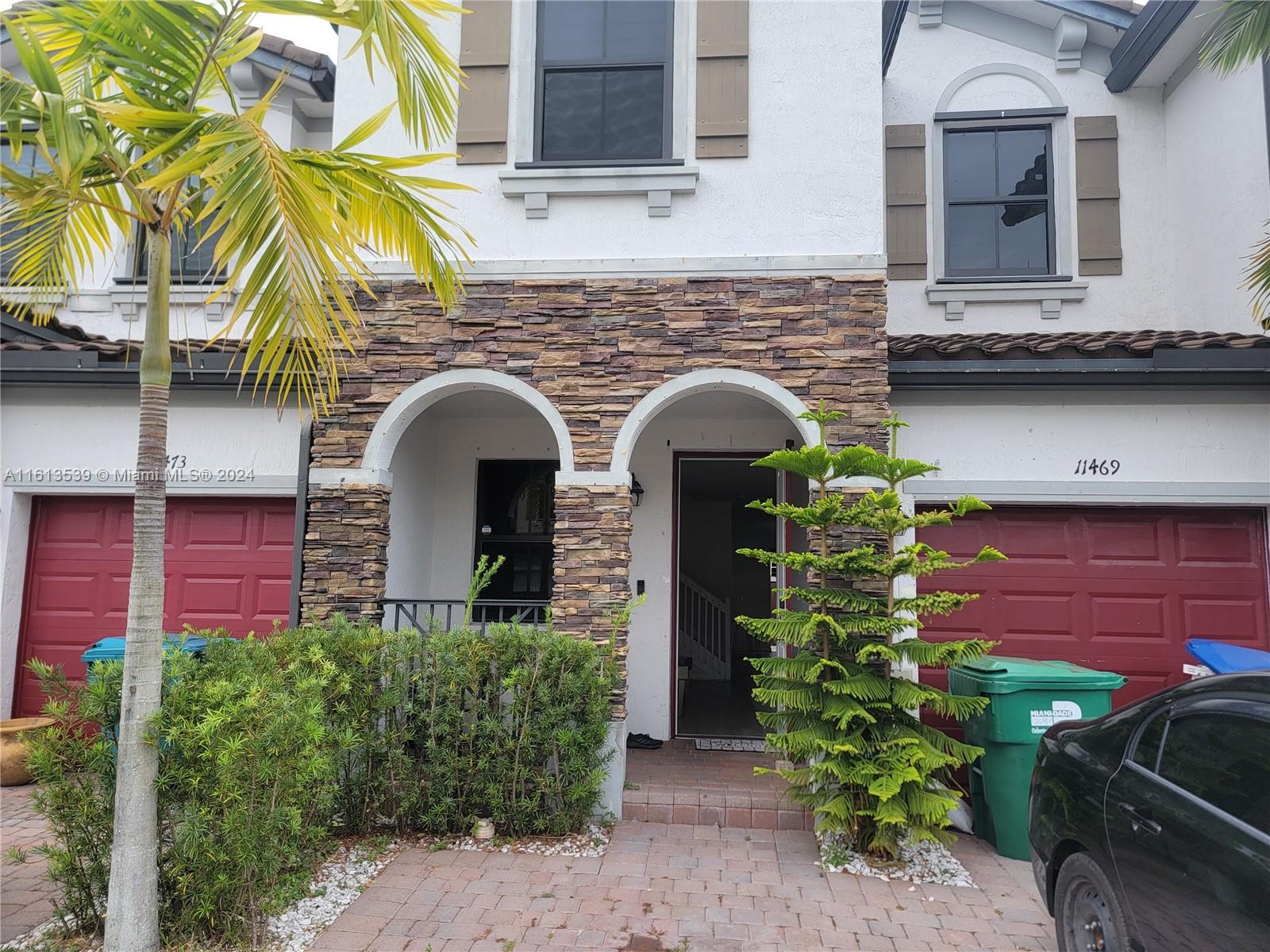 a front view of a house with plants