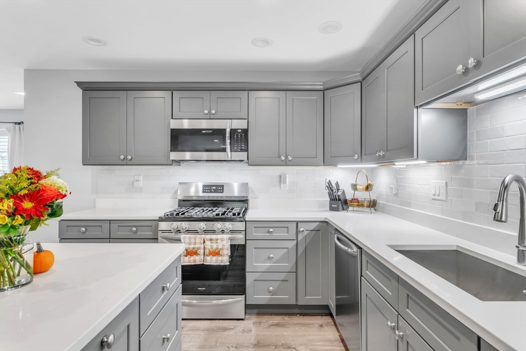 a kitchen with a sink cabinets and a stove top oven