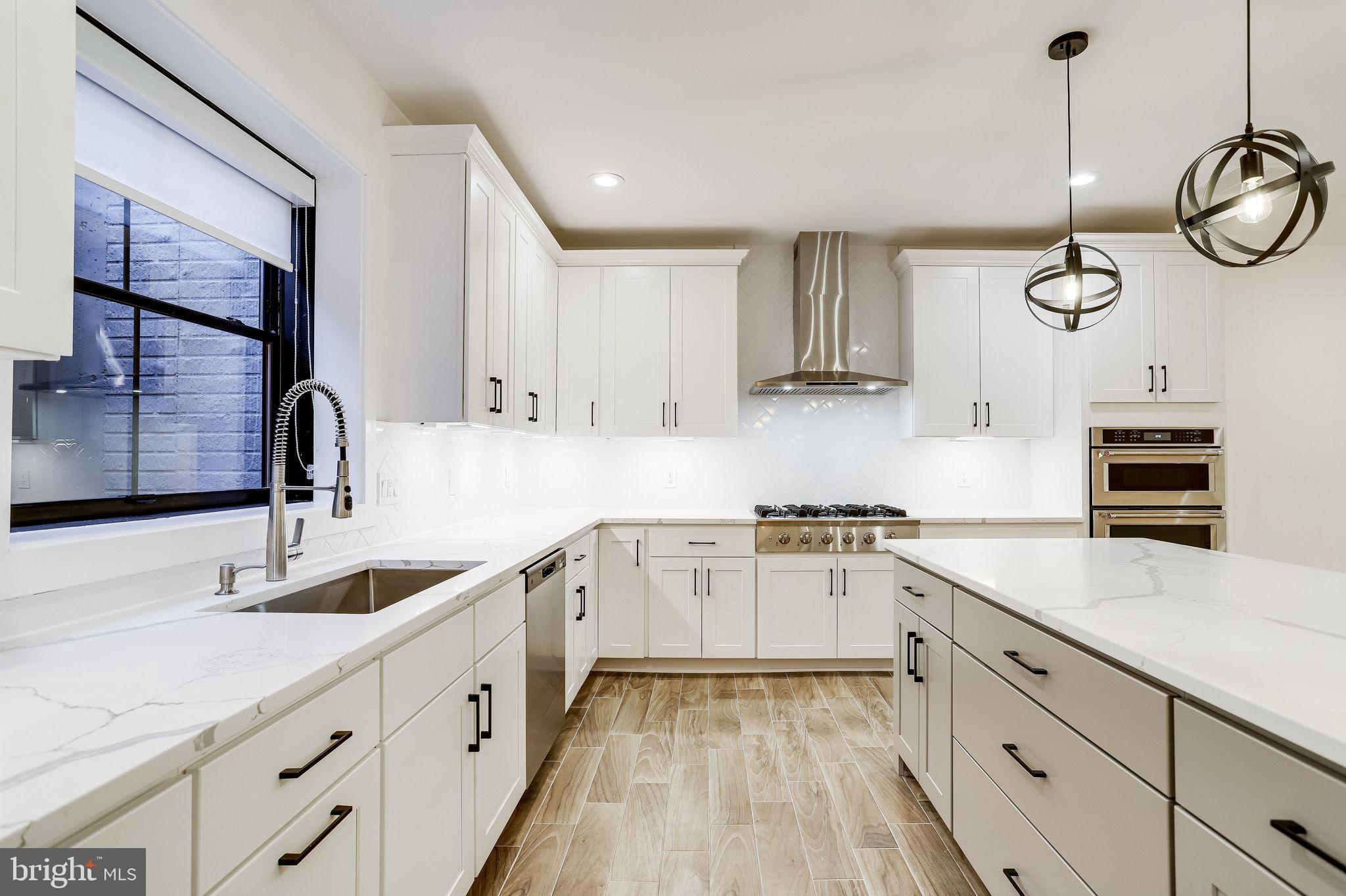 a kitchen with cabinets stainless steel appliances a sink and a stove