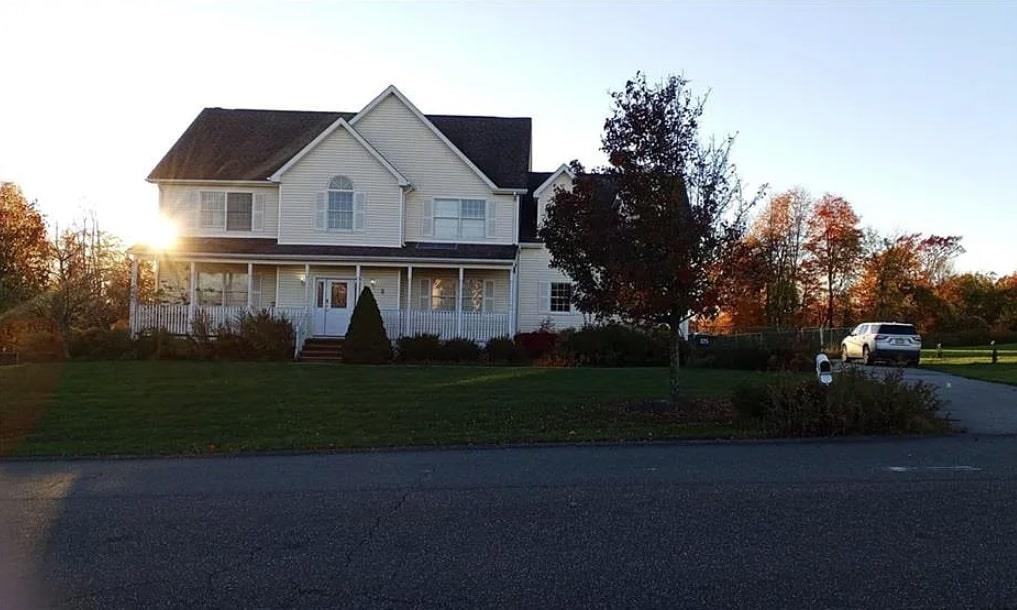 View of front facade with a front lawn and covered porch