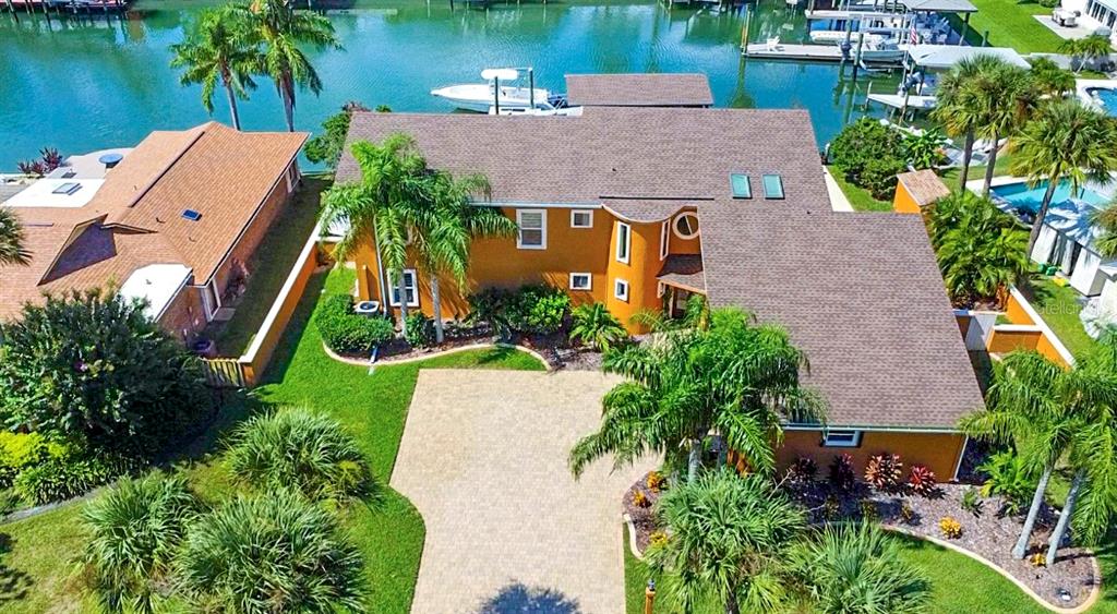 an aerial view of a house with a yard and large trees