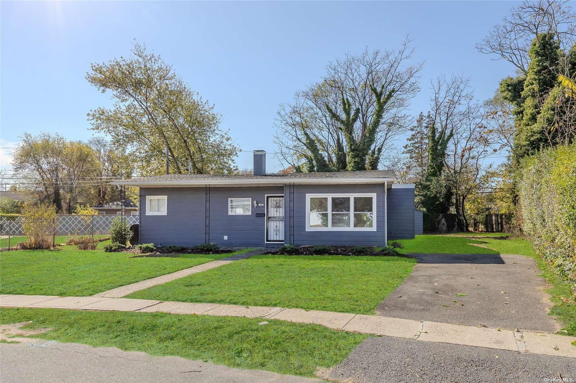 a brick house next to a yard with big trees