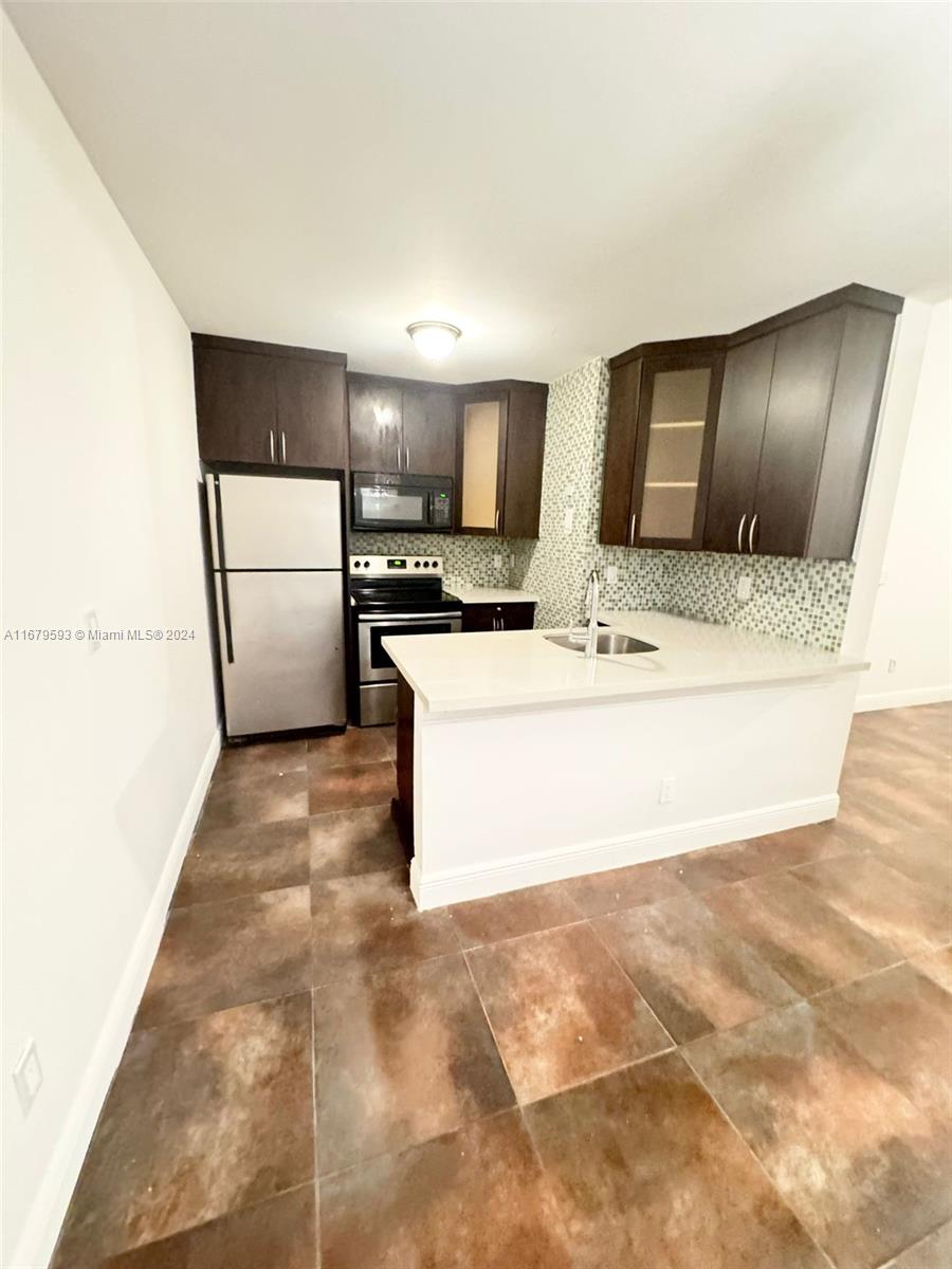 a view of kitchen with stainless steel appliances cabinets