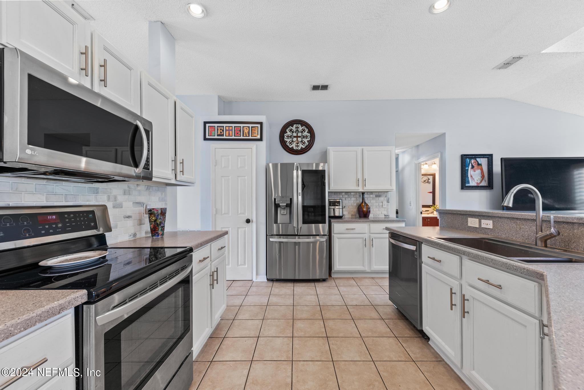 a kitchen with a sink cabinets and stainless steel appliances