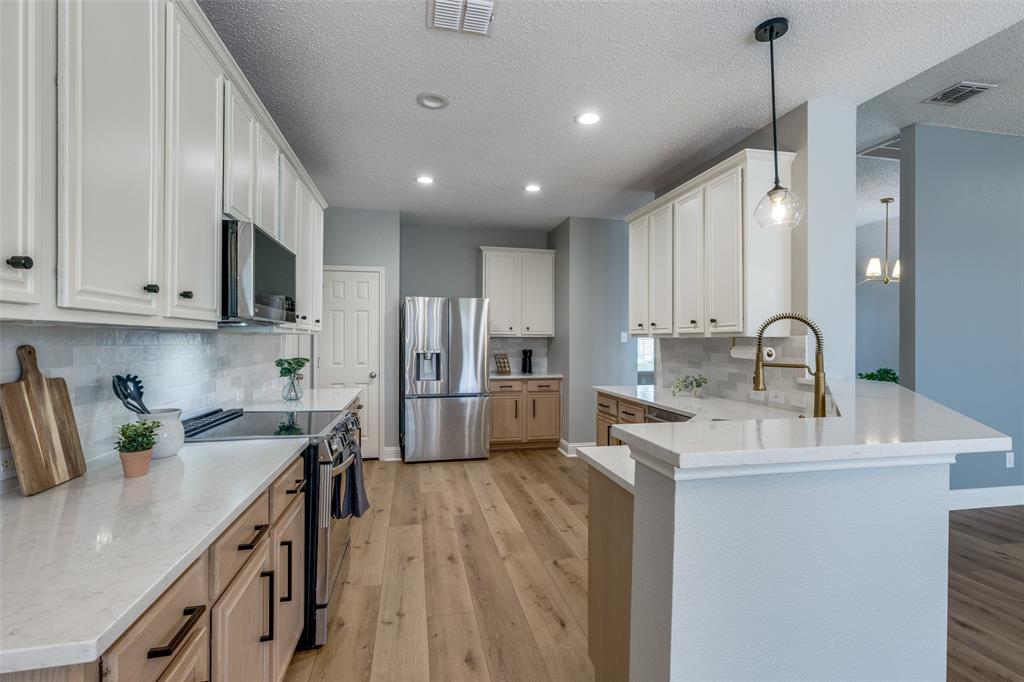 a kitchen with granite countertop a sink a counter space appliances and cabinets