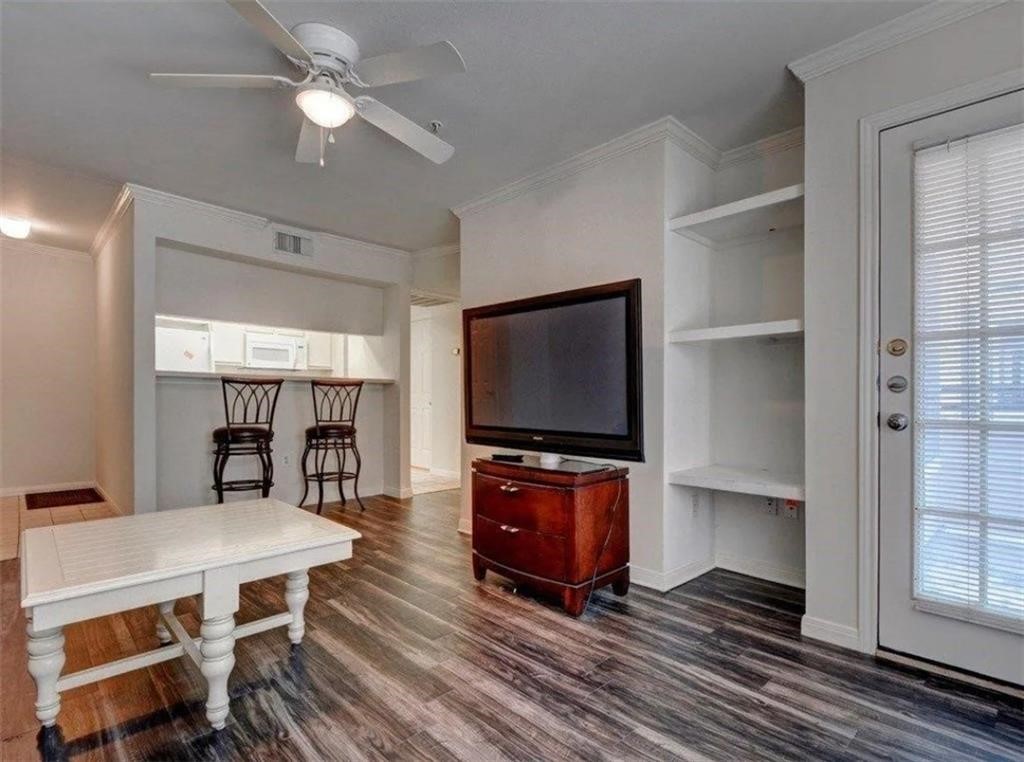 a living room with furniture a flat screen tv and kitchen view