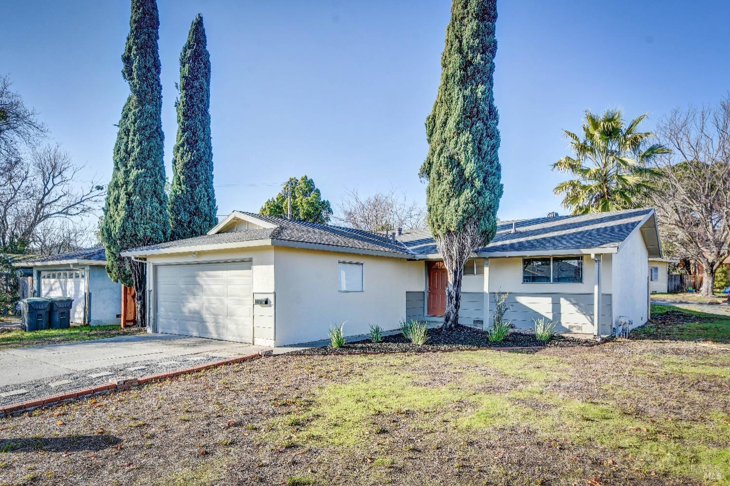 a front view of house with yard and trees