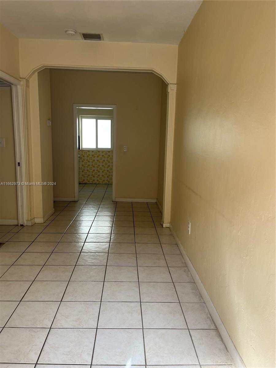 a view of a hallway with a shower and a window