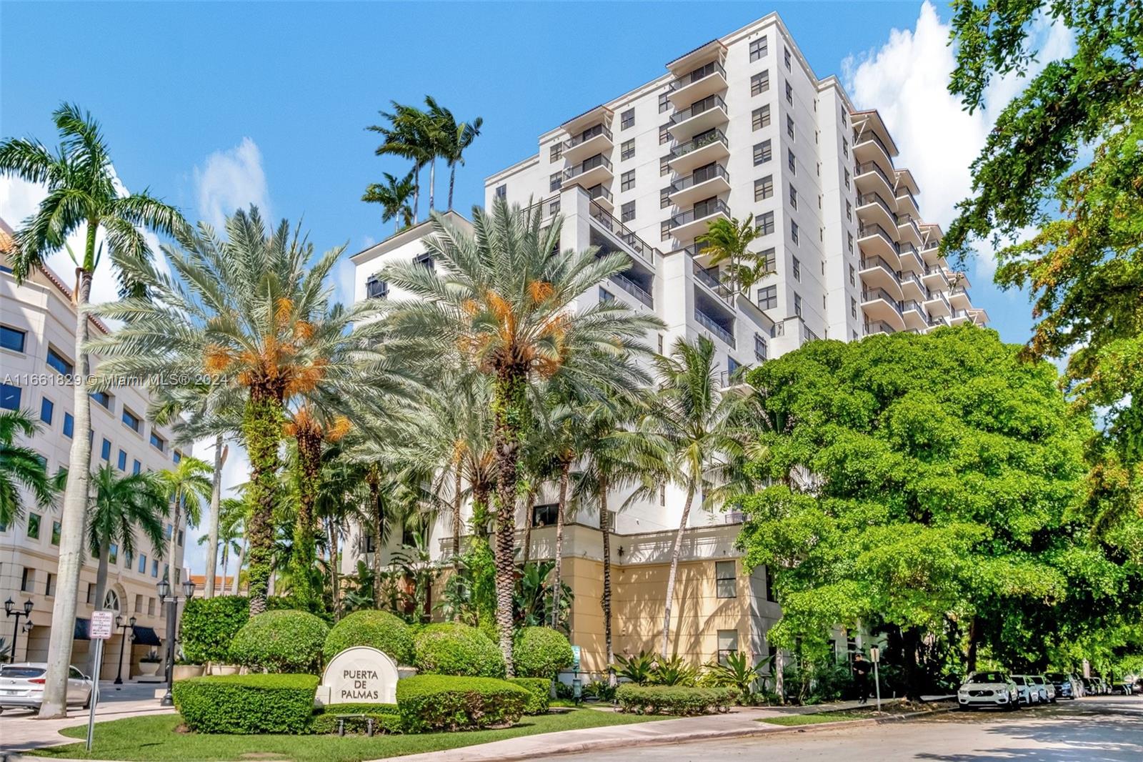 a front view of multi story residential apartment building with yard and green space