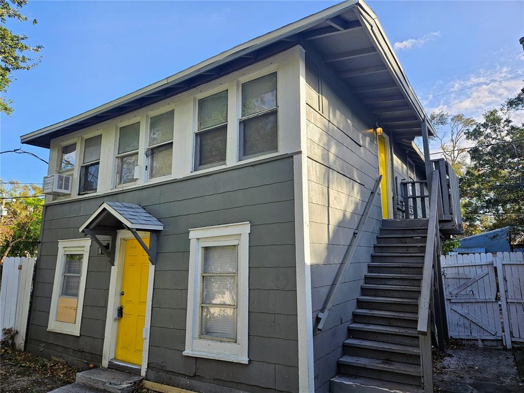 a view of a house with wooden stairs and a small yard