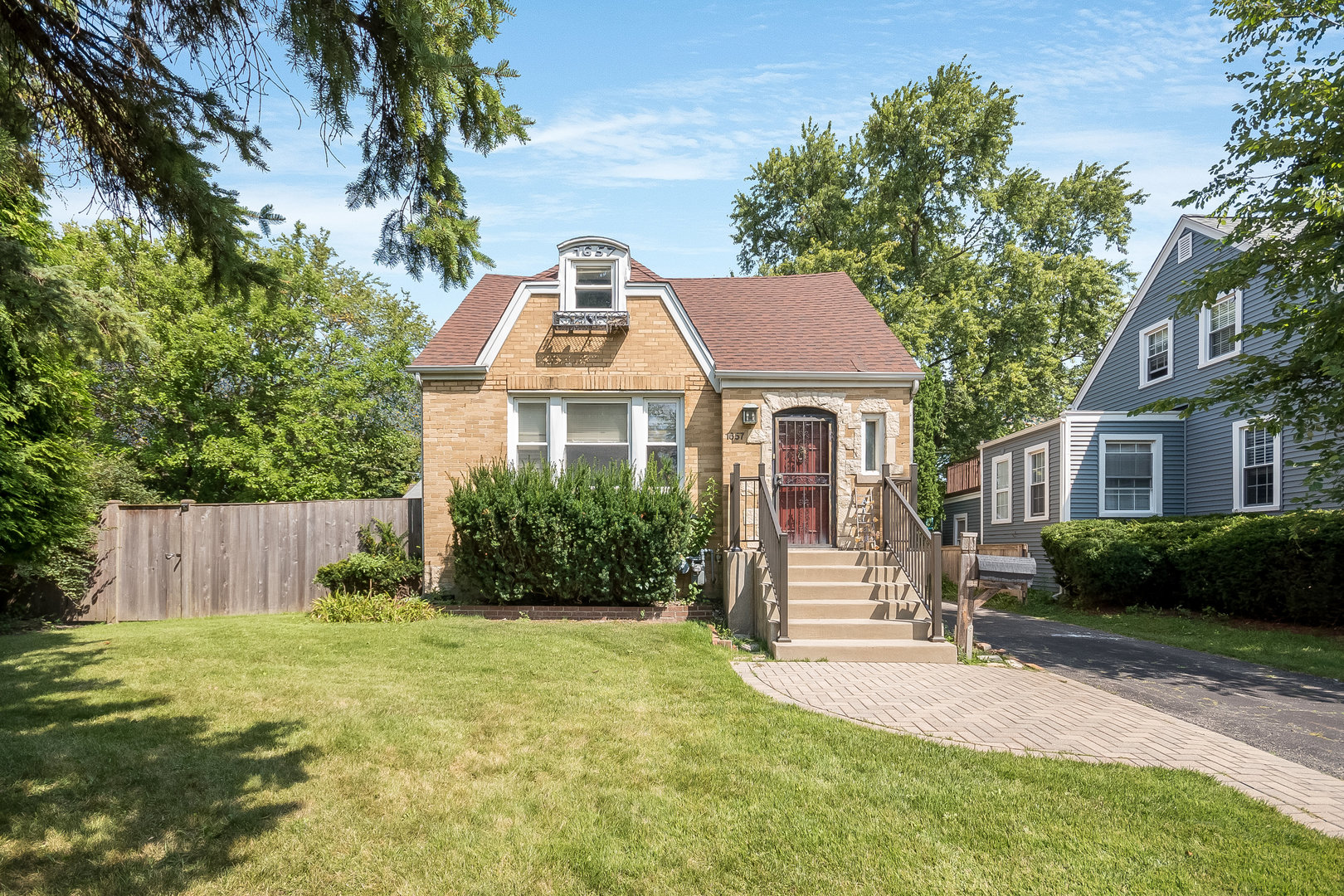 a front view of a house with a yard and tree