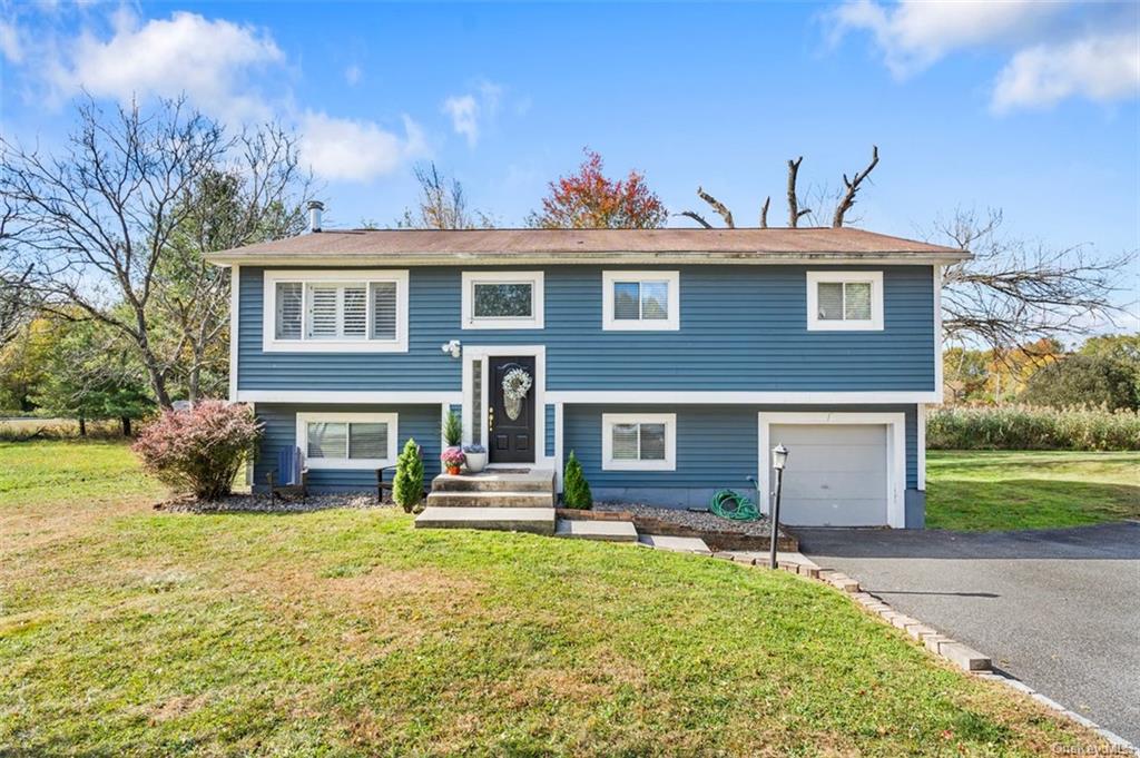 Bi-level home featuring a front yard and a garage