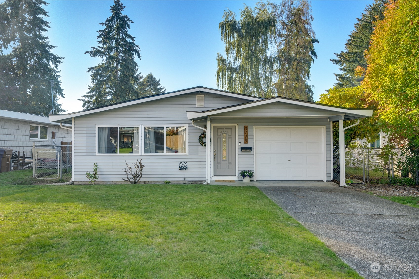 a front view of a house with a yard and trees