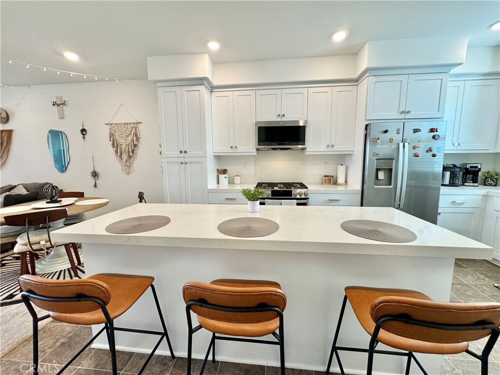 a kitchen with stainless steel appliances granite countertop a sink and a refrigerator