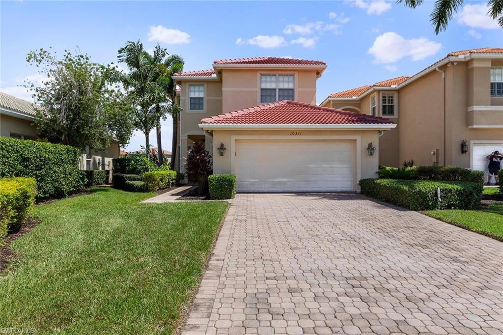 a front view of a house with a yard and a garage