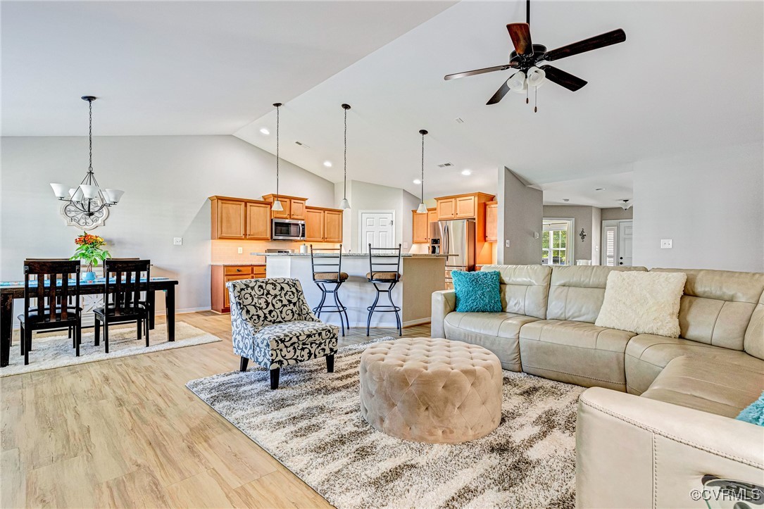 a living room with furniture kitchen view and a chandelier