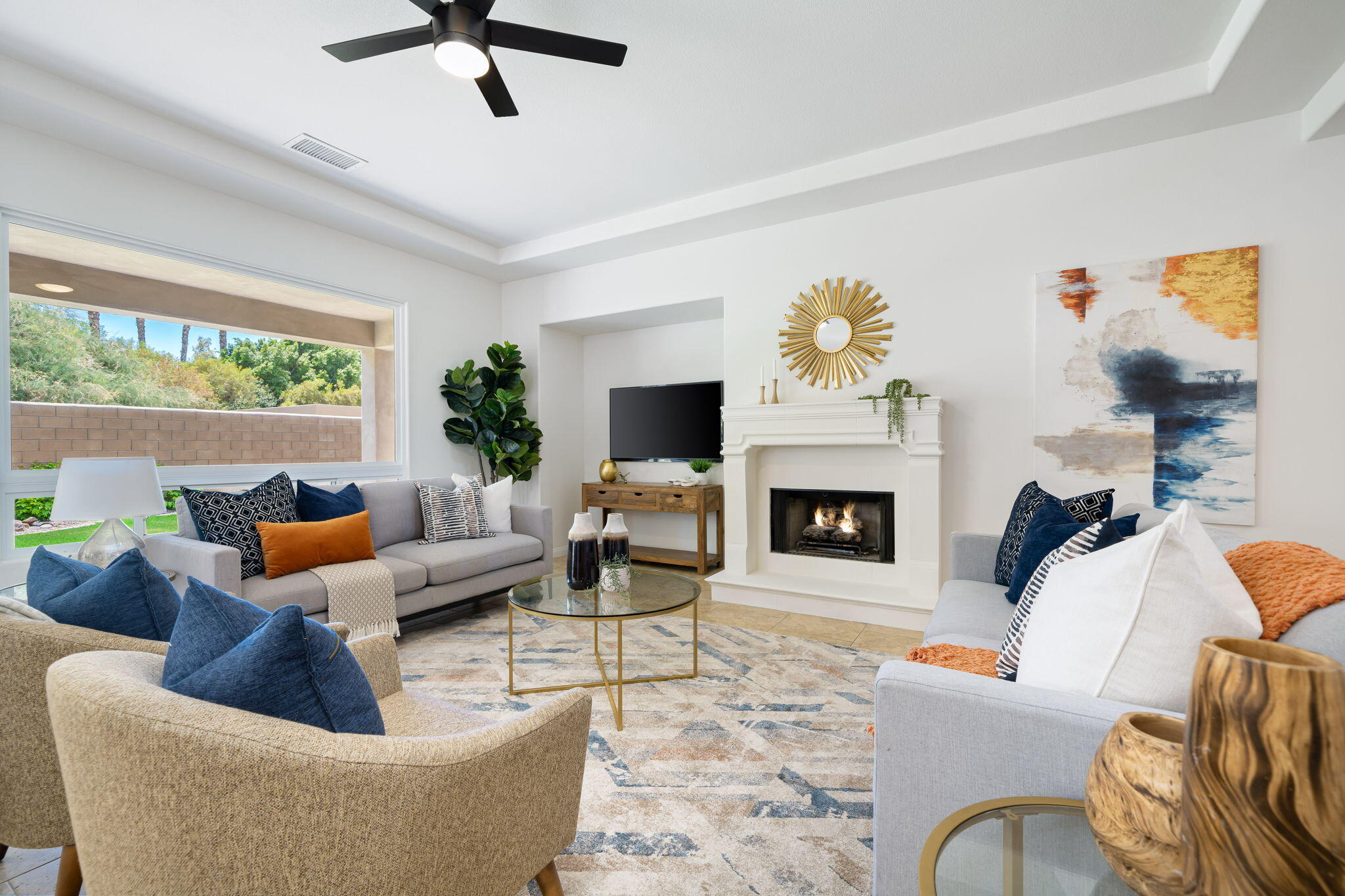 a living room with furniture a fireplace and a large window