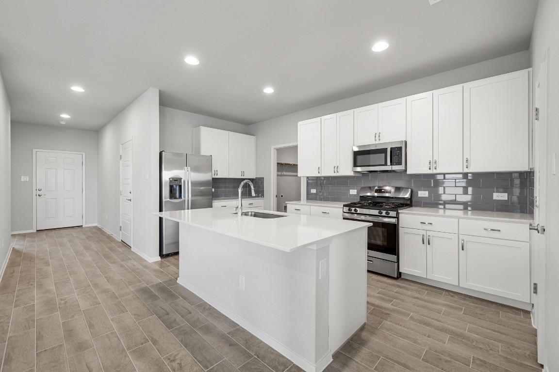 a kitchen with white cabinets and stainless steel appliances