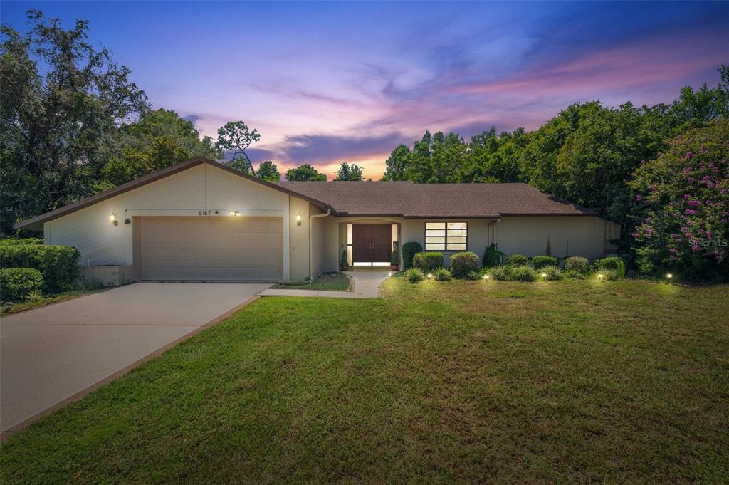 a front view of a house with a yard and trees