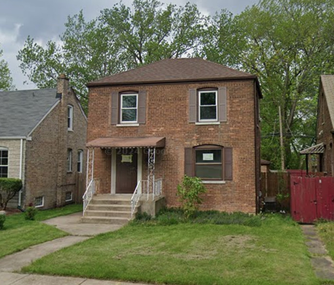 a view of a house with a yard and a large tree