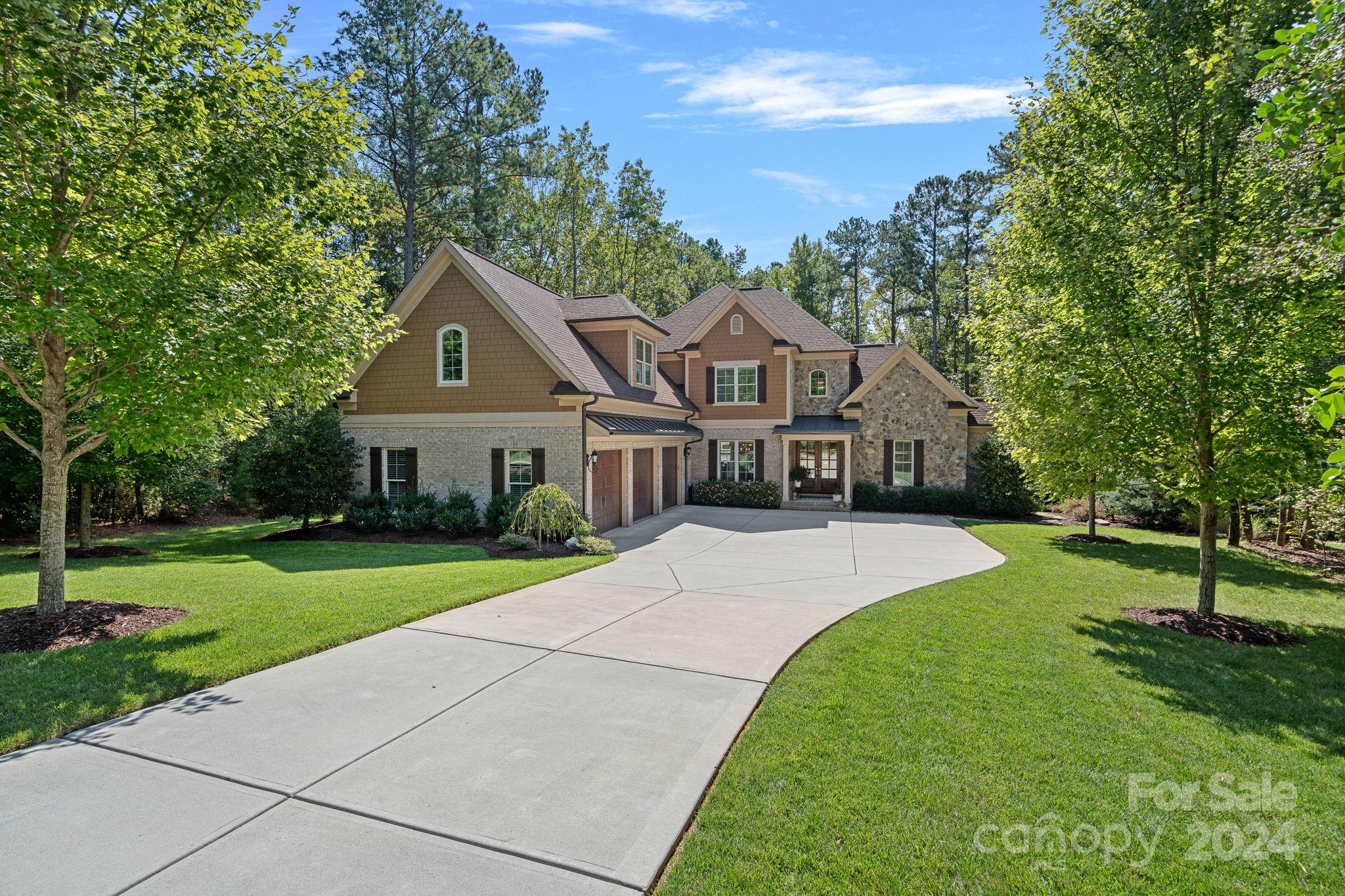 a front view of a house with a yard and trees