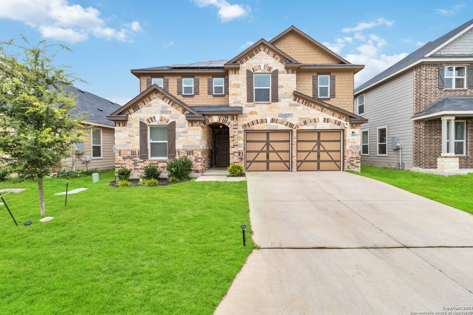 a front view of a house with a yard and garage