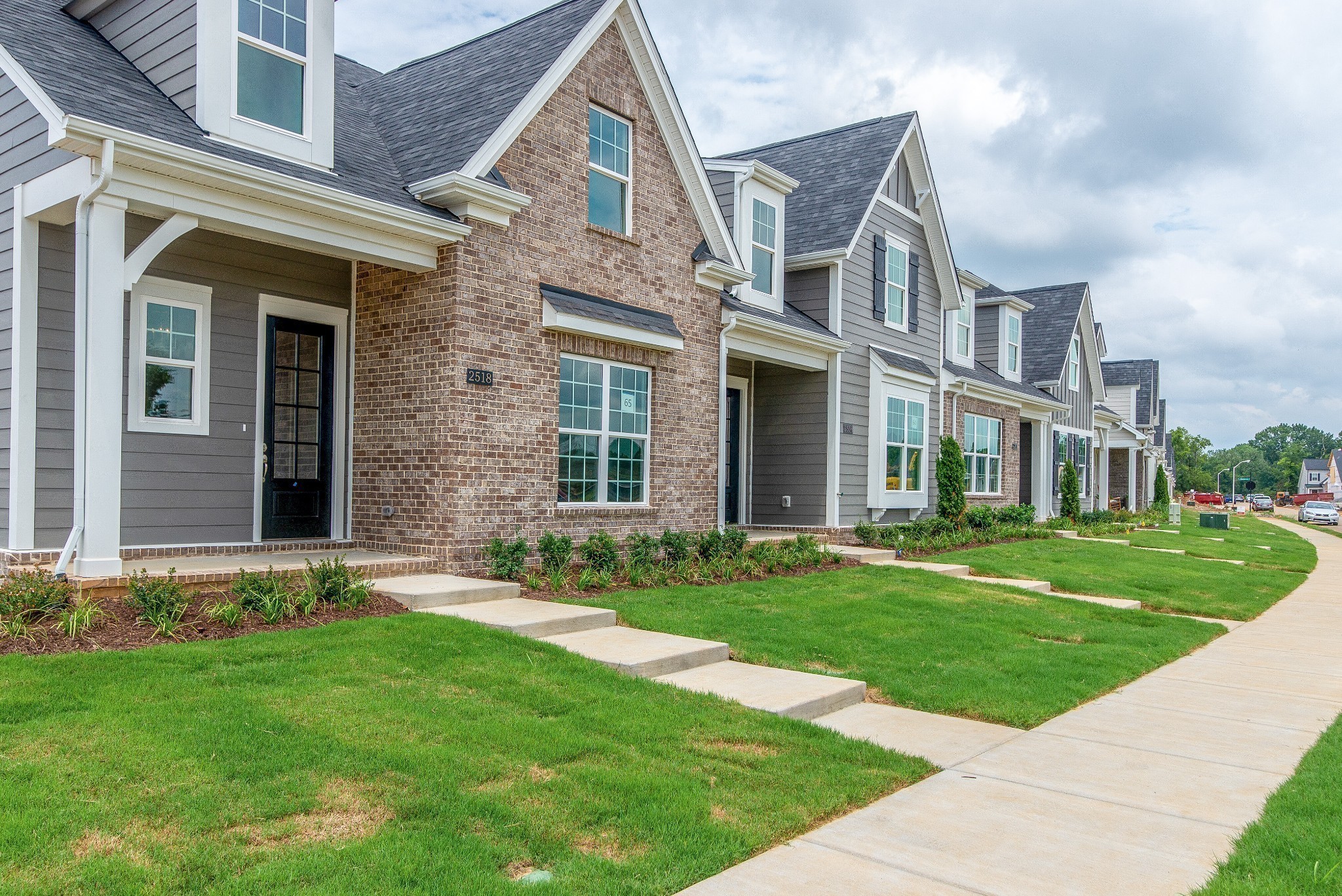 front view of a brick house with a yard