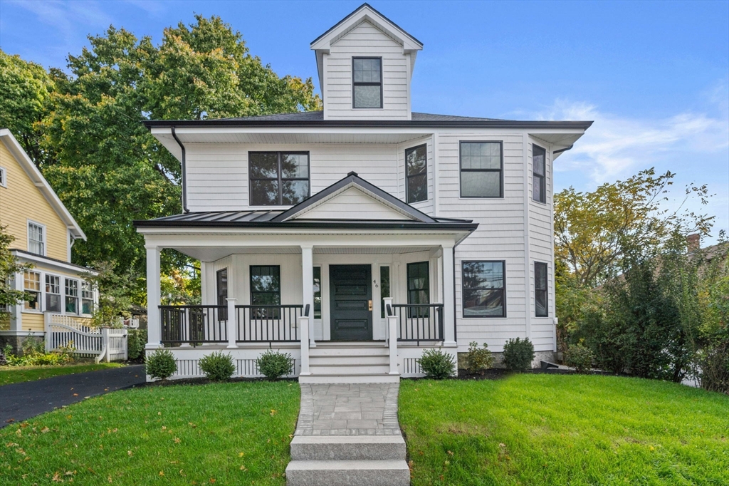 a front view of a house with a yard and potted plants