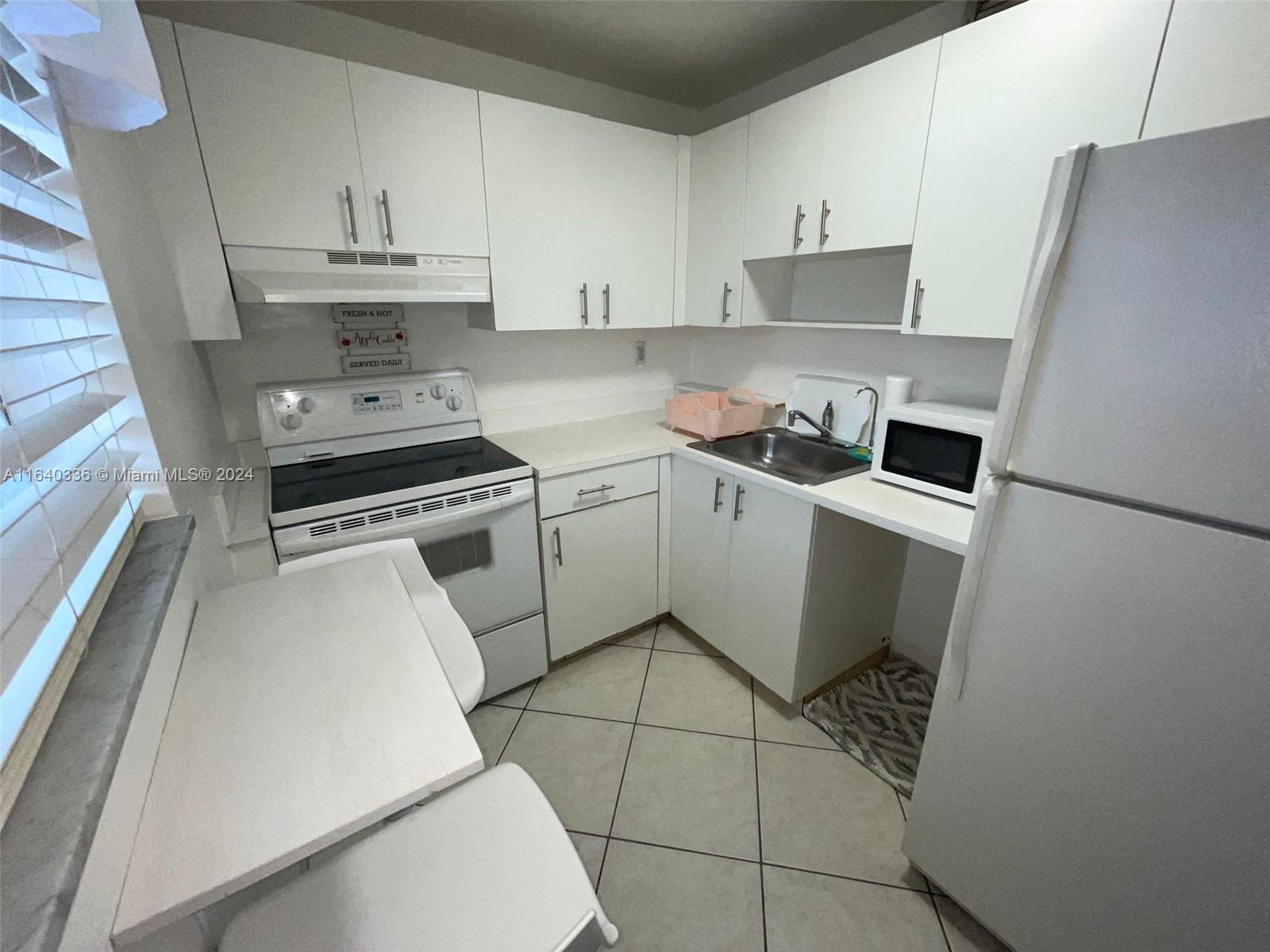 a kitchen with cabinets and steel appliances