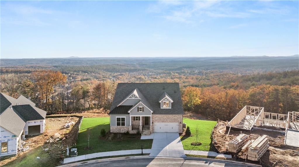 an aerial view of a house with a garden and lake view