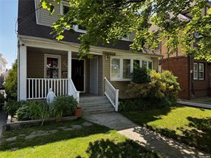 View of front of property featuring covered porch and a front lawn