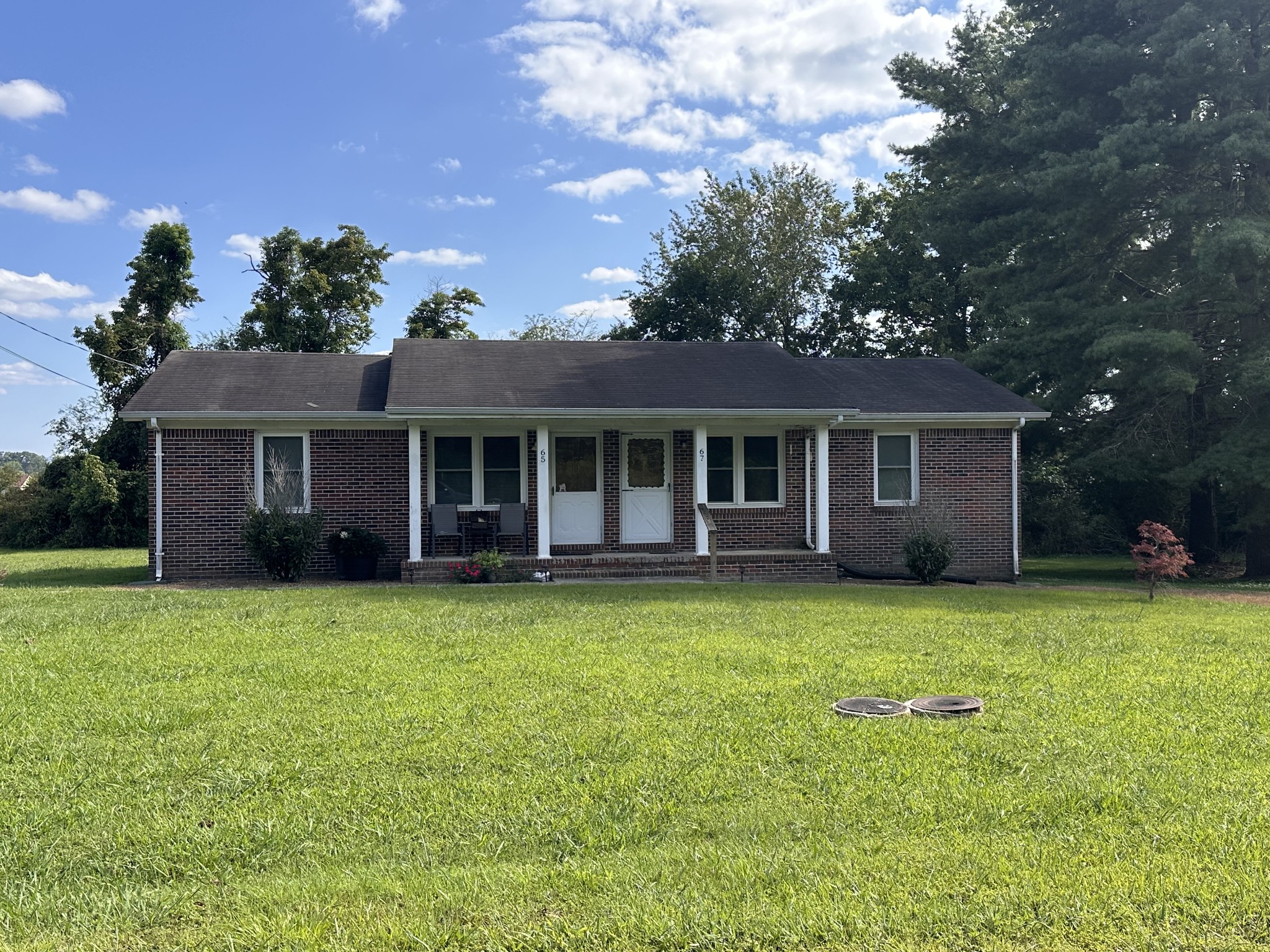 a front view of house with yard and green space