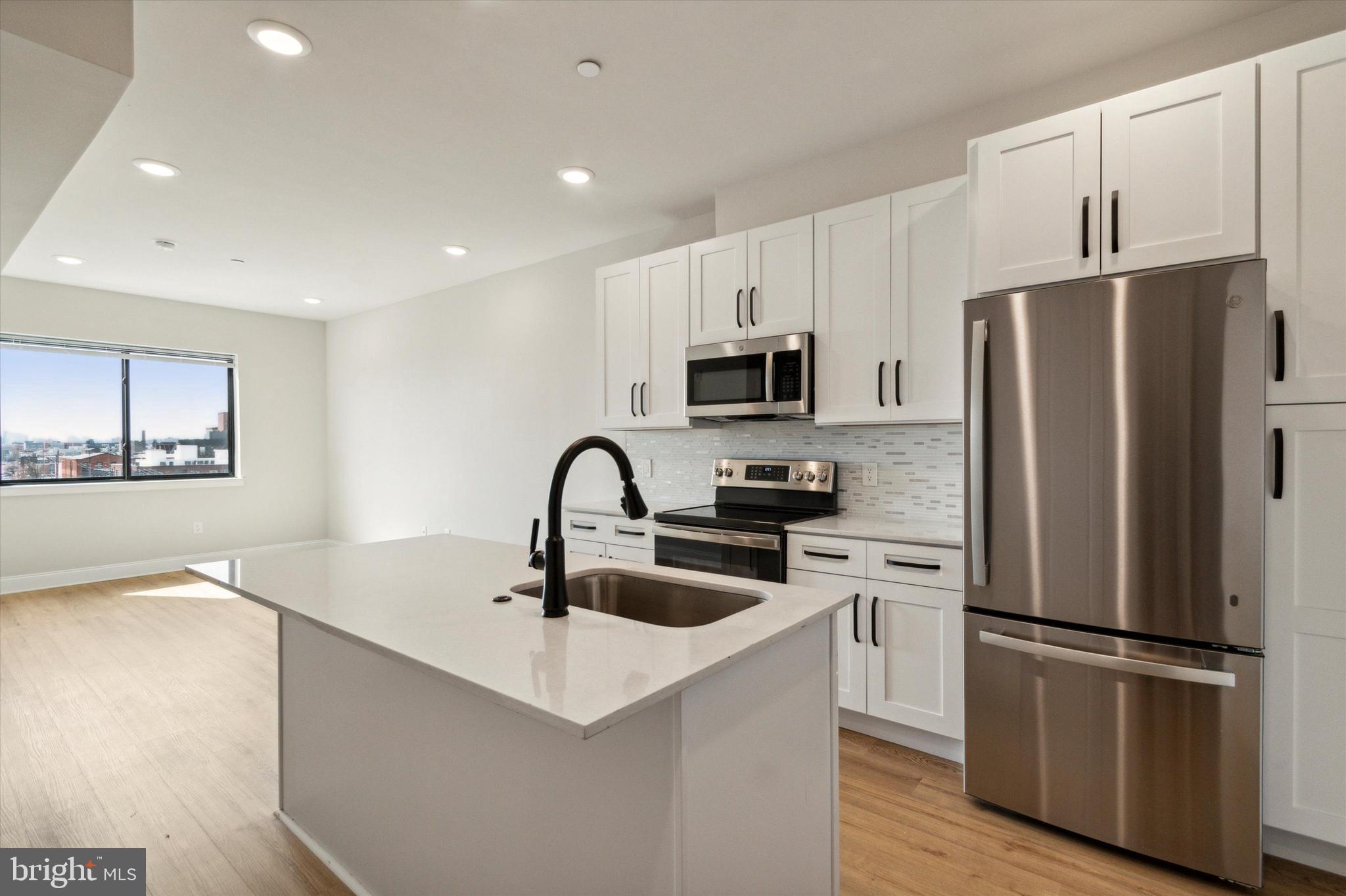 a kitchen with stainless steel appliances a refrigerator stove microwave and sink