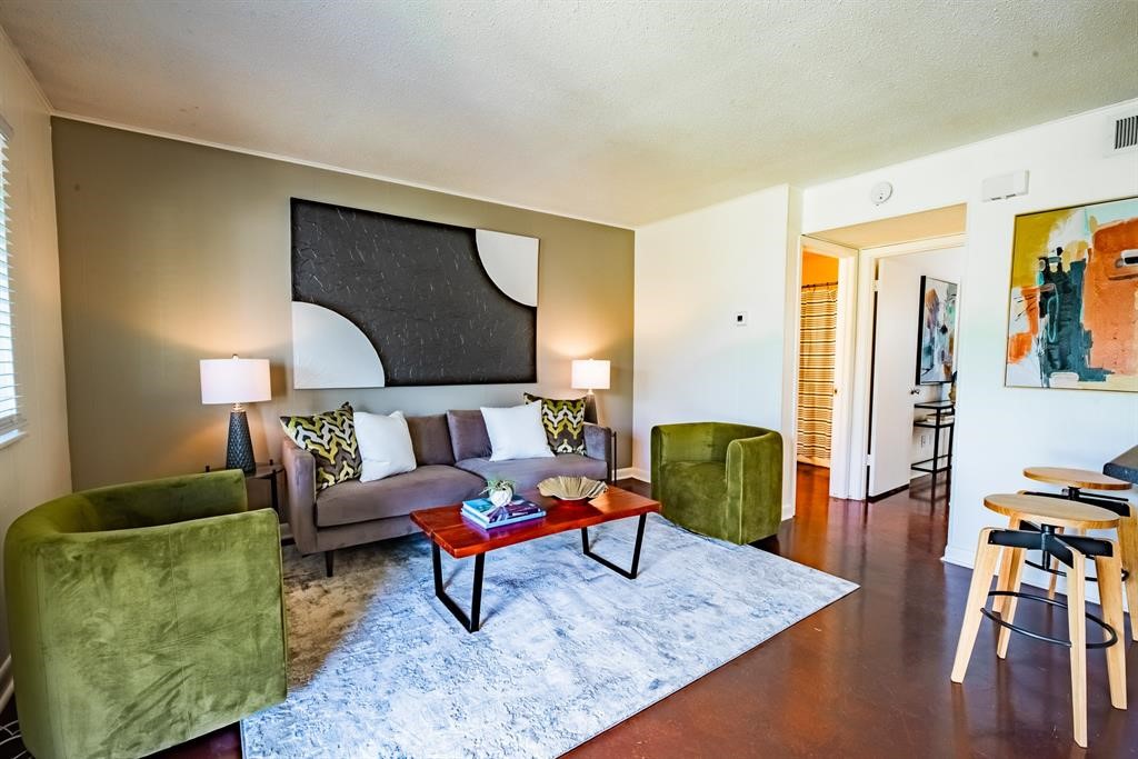 a living room with furniture and a wooden floor