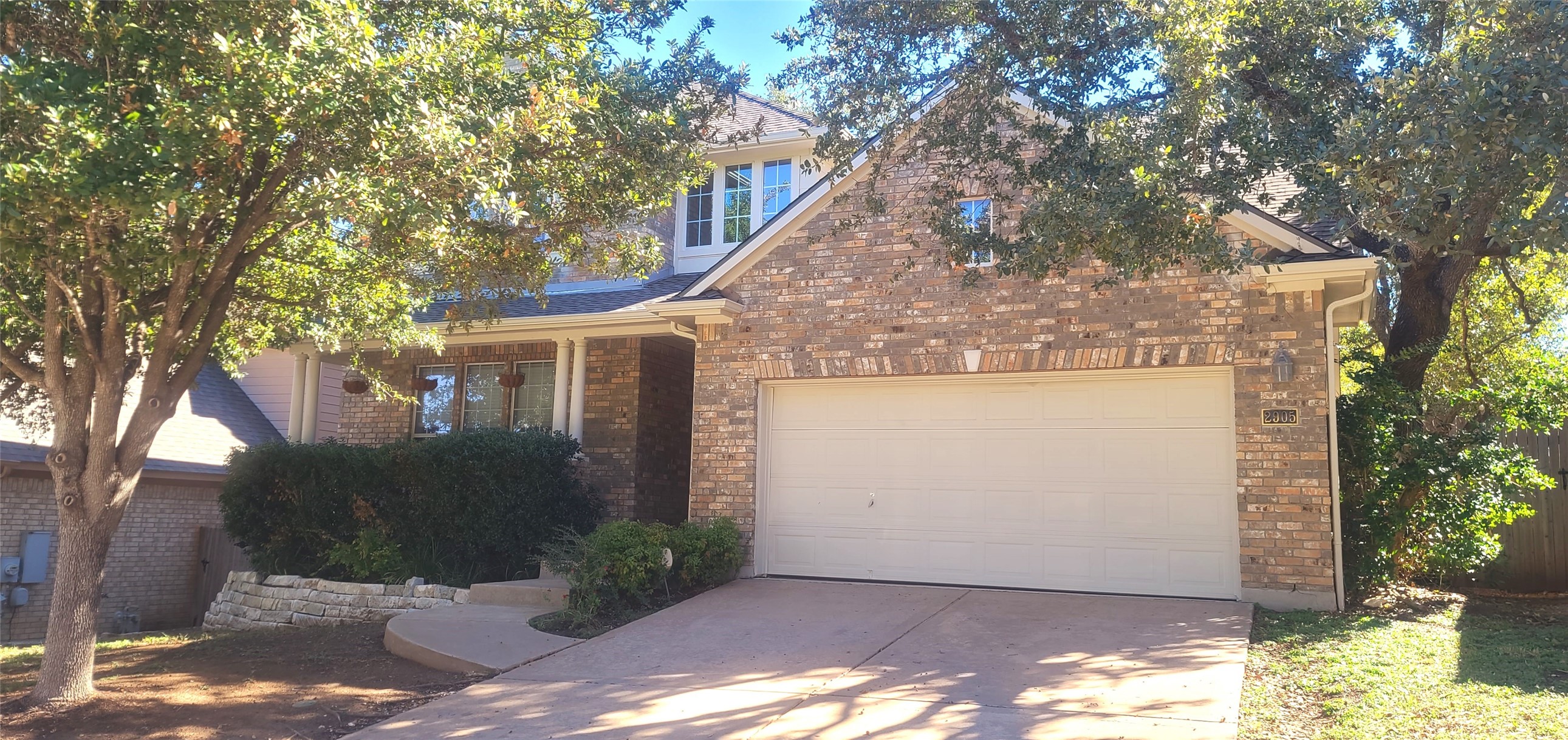 a view of a small space in front of a house with large trees