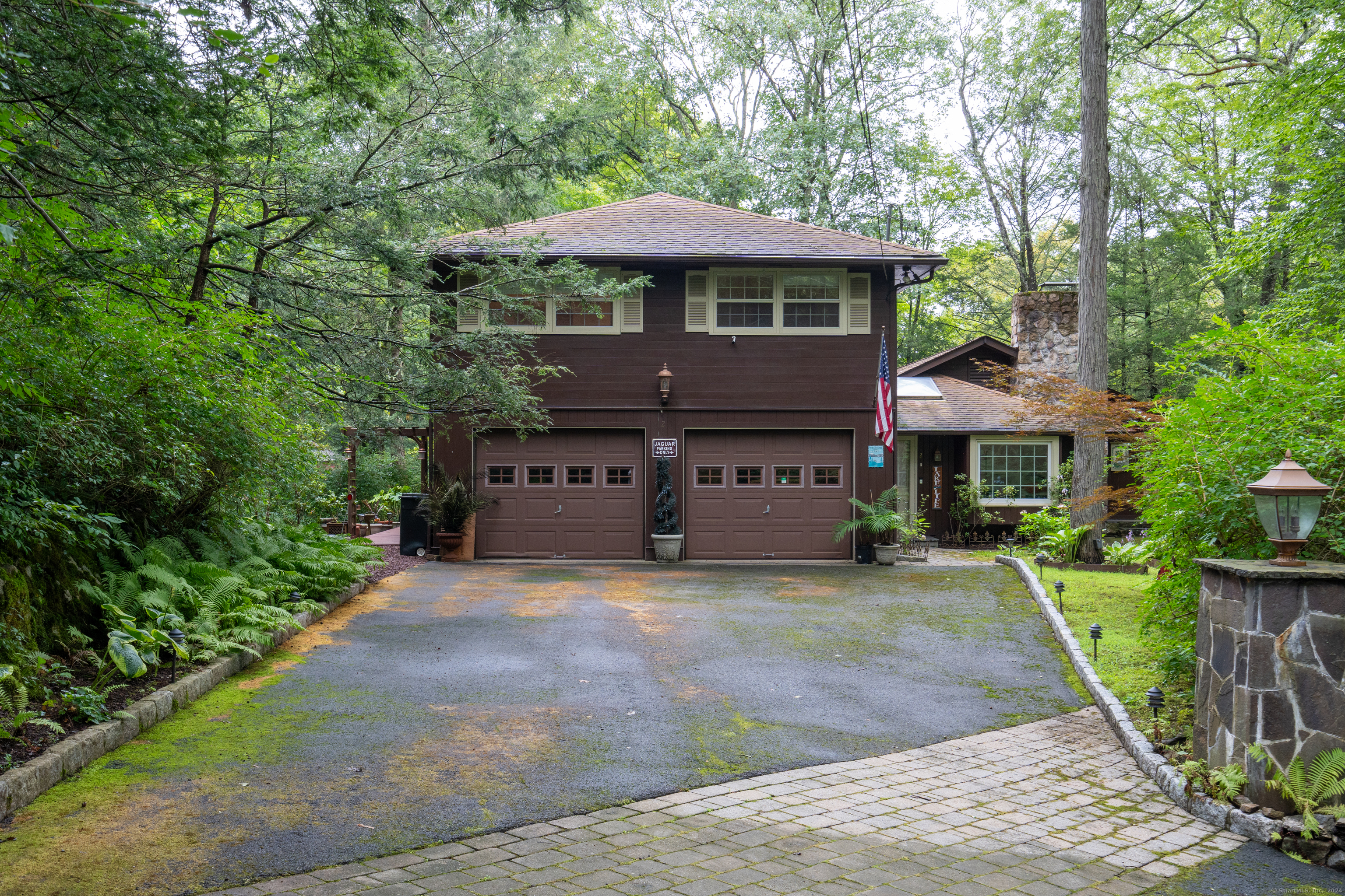 a front view of a house with a yard and green space