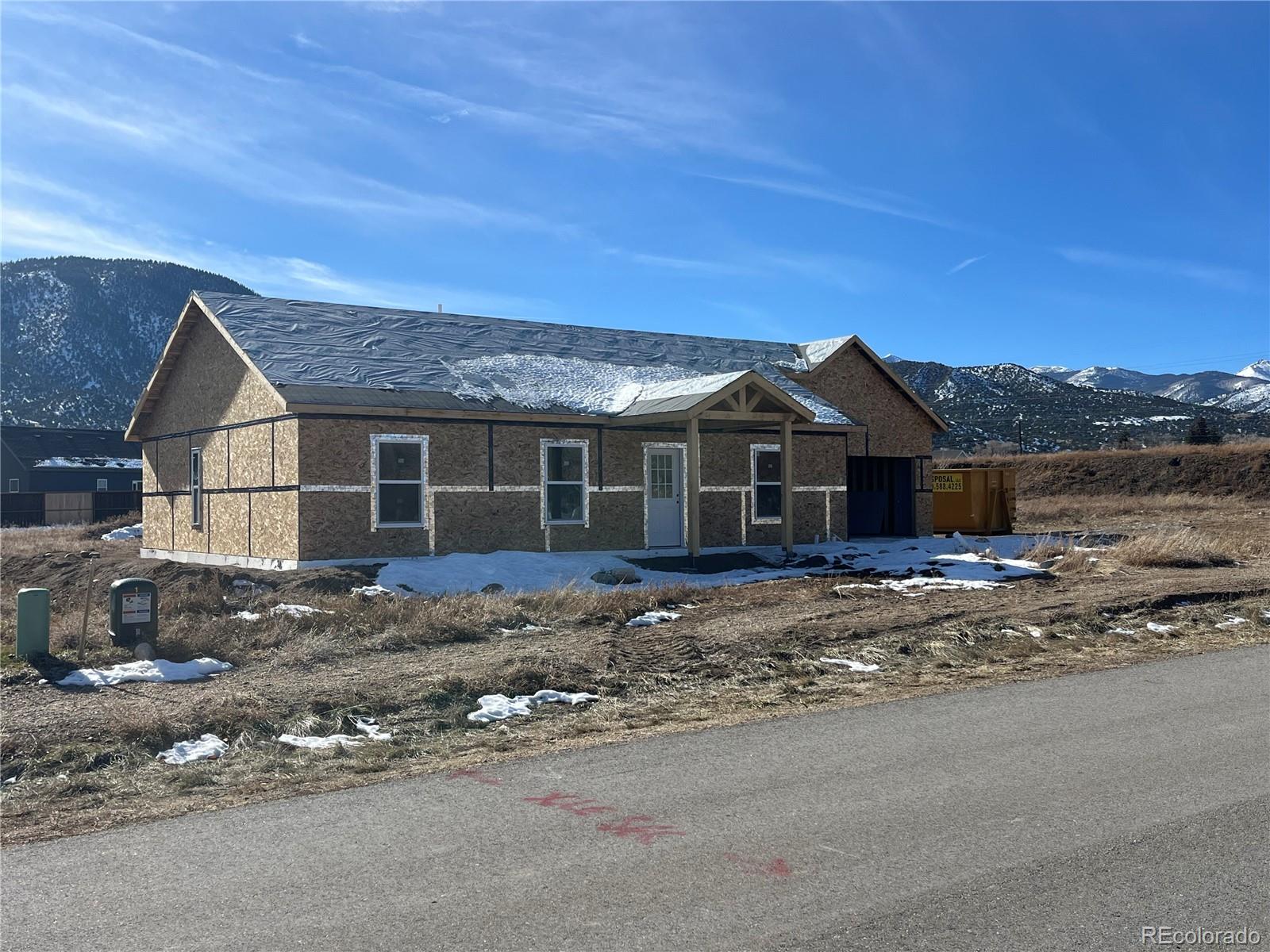 a front view of a house with a yard and mountain view