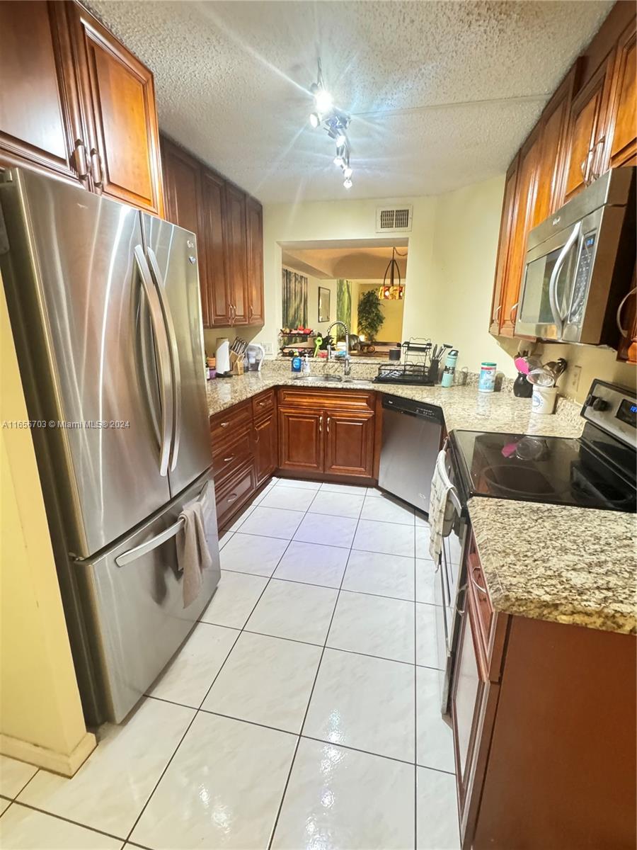 a kitchen with a sink a stove a refrigerator and cabinetry