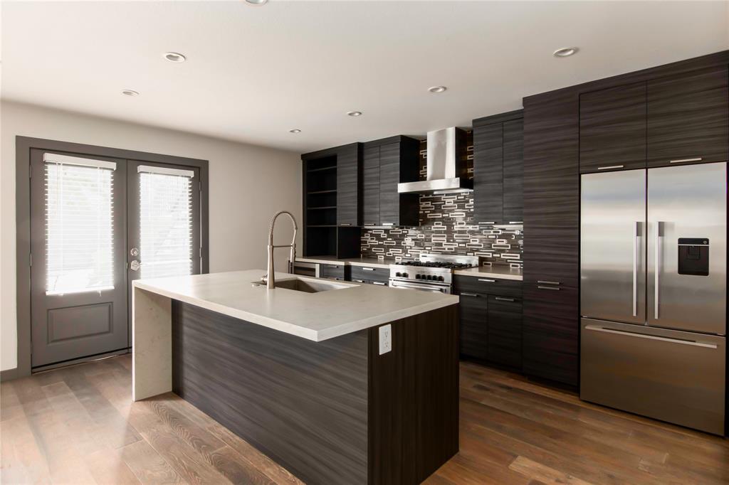 a kitchen with stainless steel appliances kitchen island granite countertop a sink stove and refrigerator