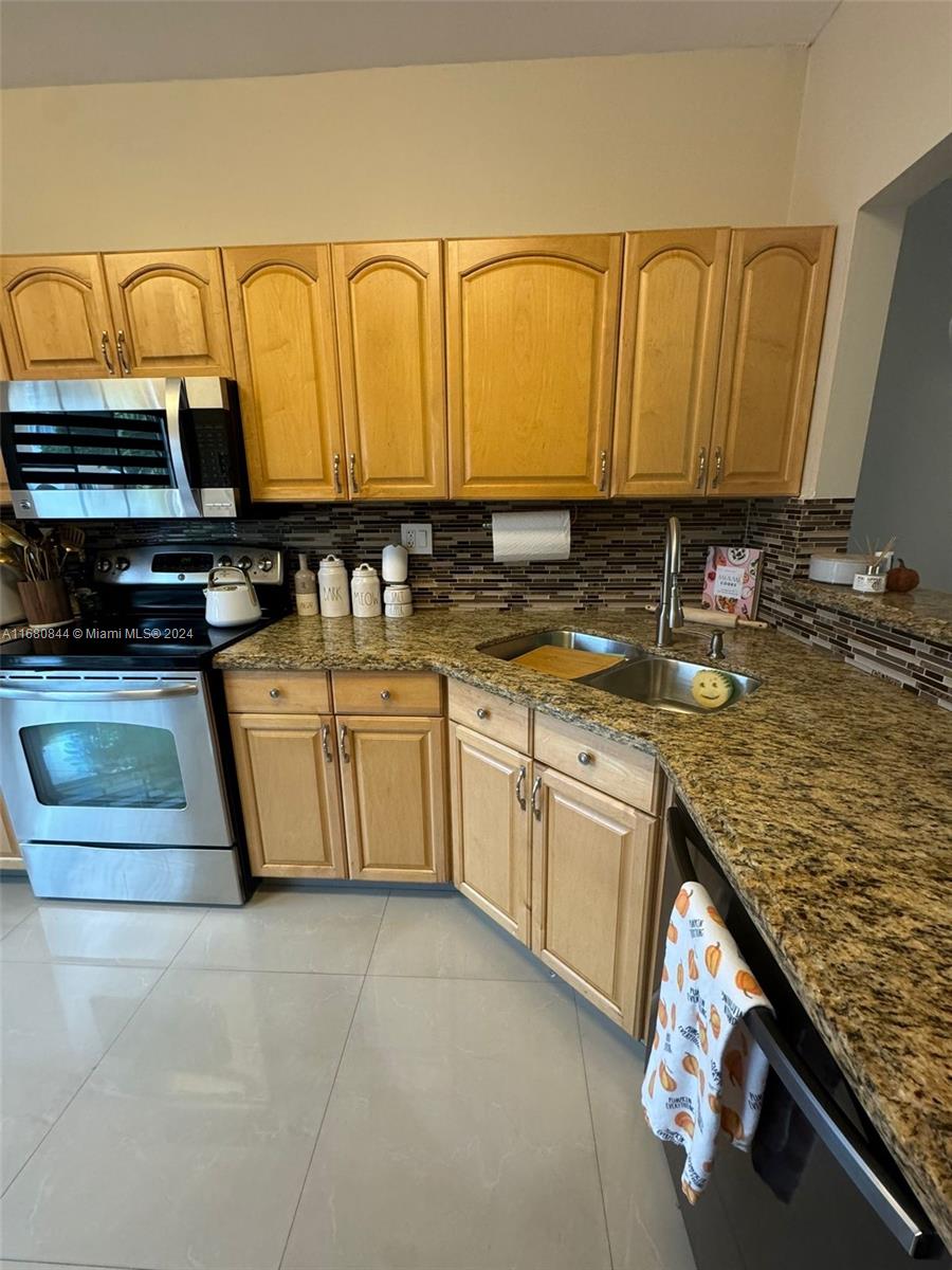 a kitchen with stainless steel appliances granite countertop a sink stove and cabinets