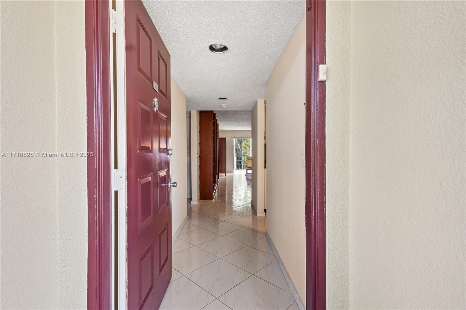 a view of a hallway with closet and a bathroom