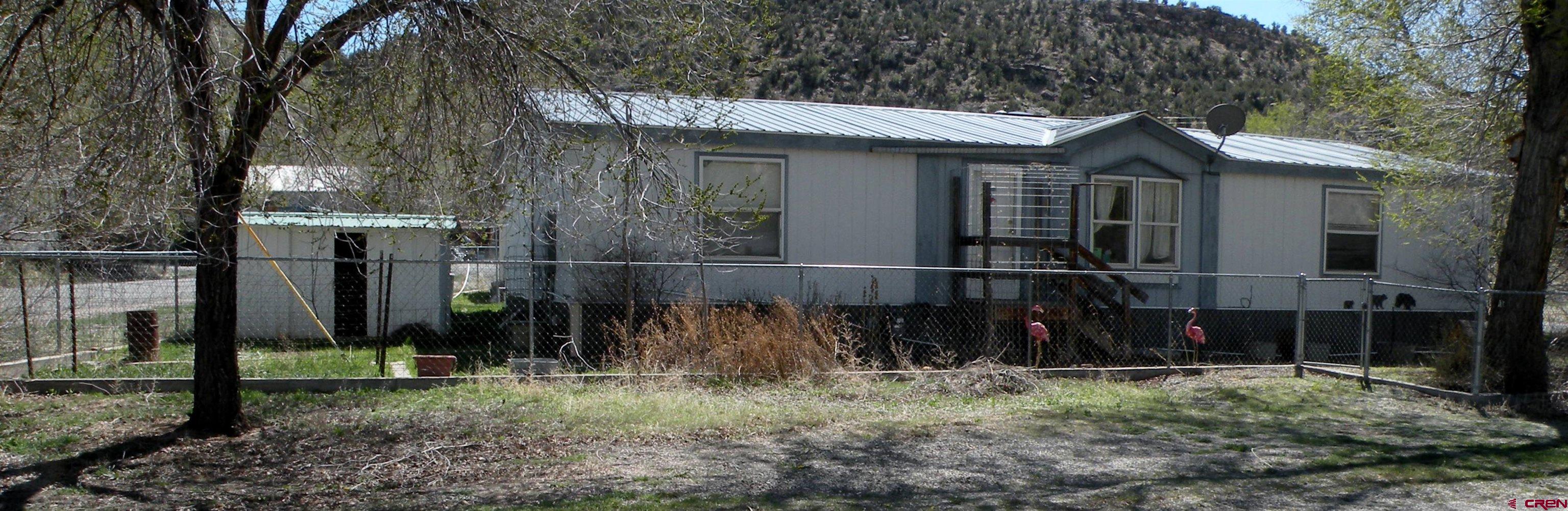 a view of a house with a yard and wooden fence