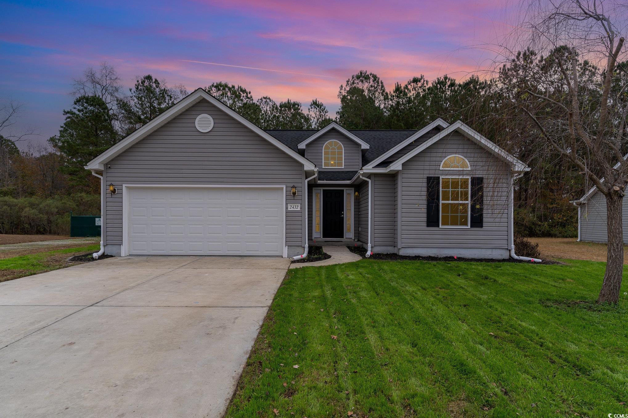 Ranch-style house featuring a lawn and a garage