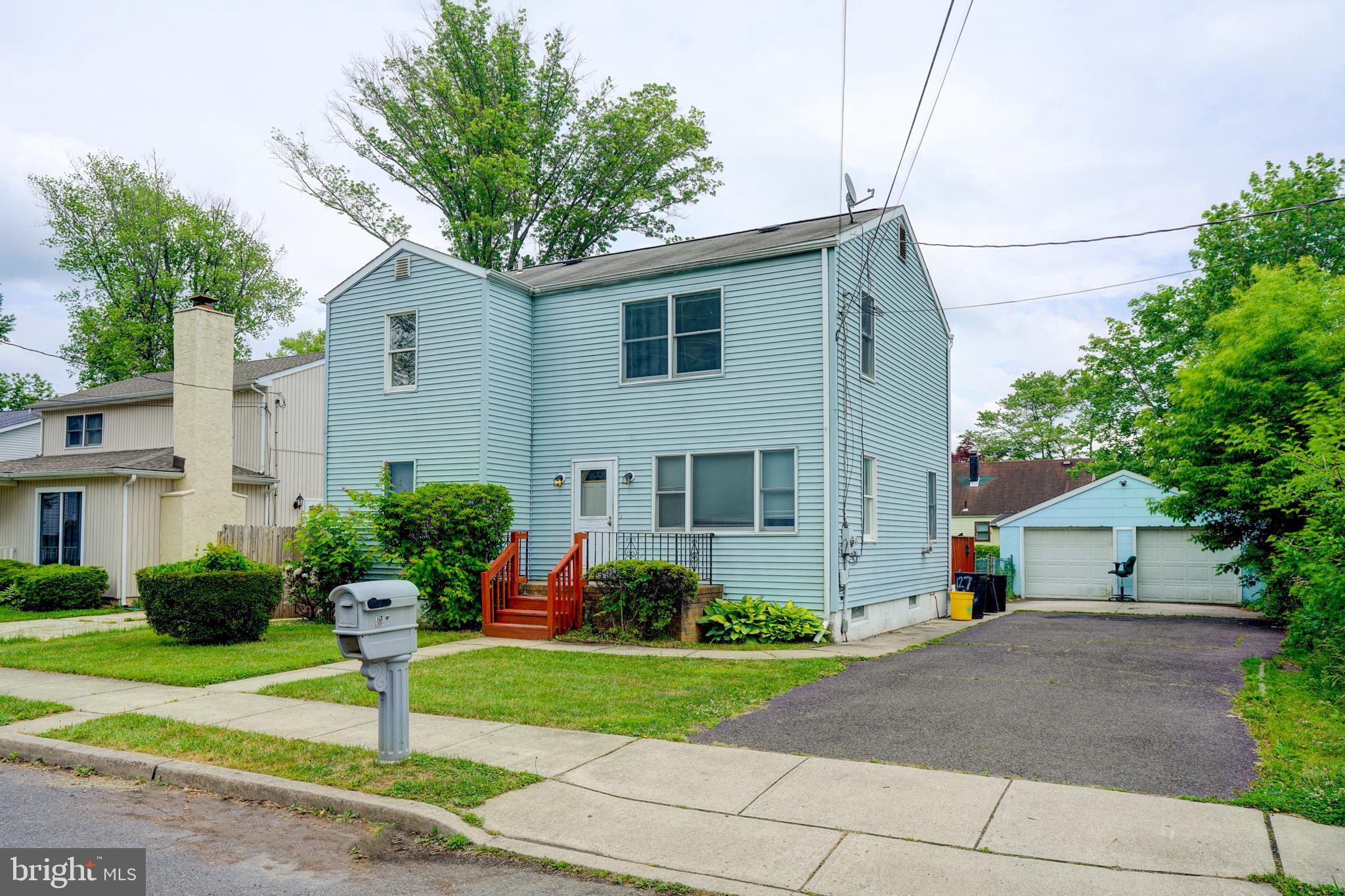 a front view of a house with a yard and potted plants