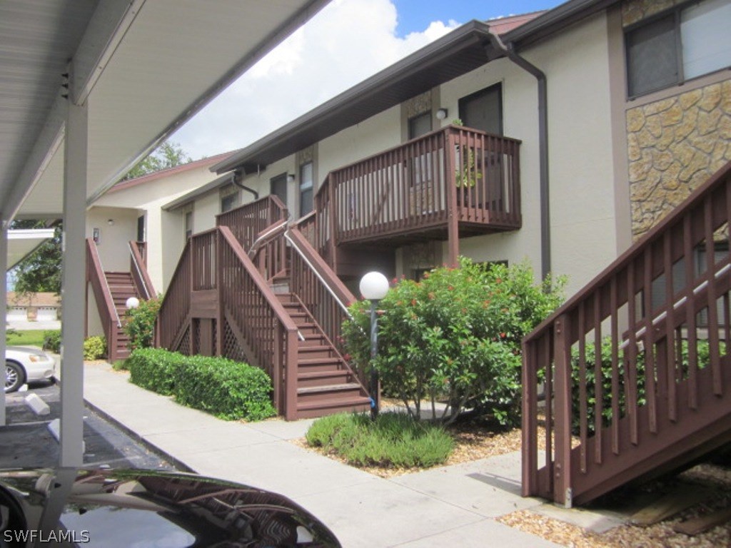 a view of a house with wooden stairs and a small yard