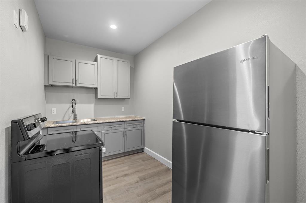 a kitchen with a refrigerator sink and cabinets