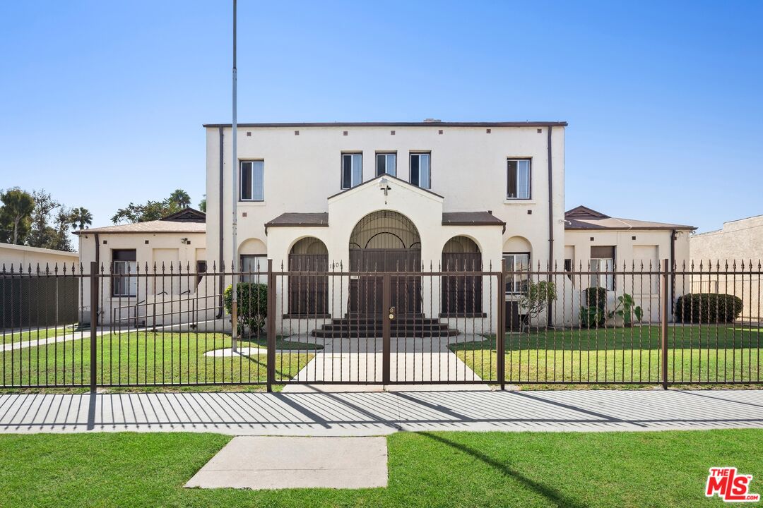 a front view of a house with a garden and fence