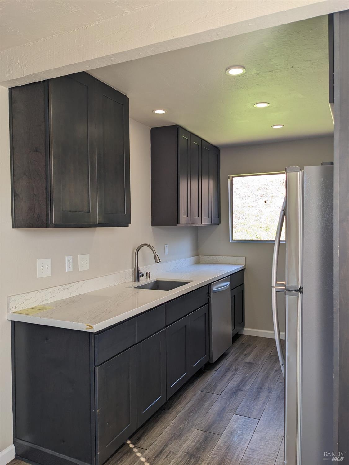 a kitchen with a sink cabinets and wooden floor