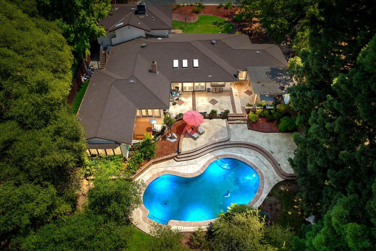 an aerial view of a house with yard swimming pool and outdoor seating